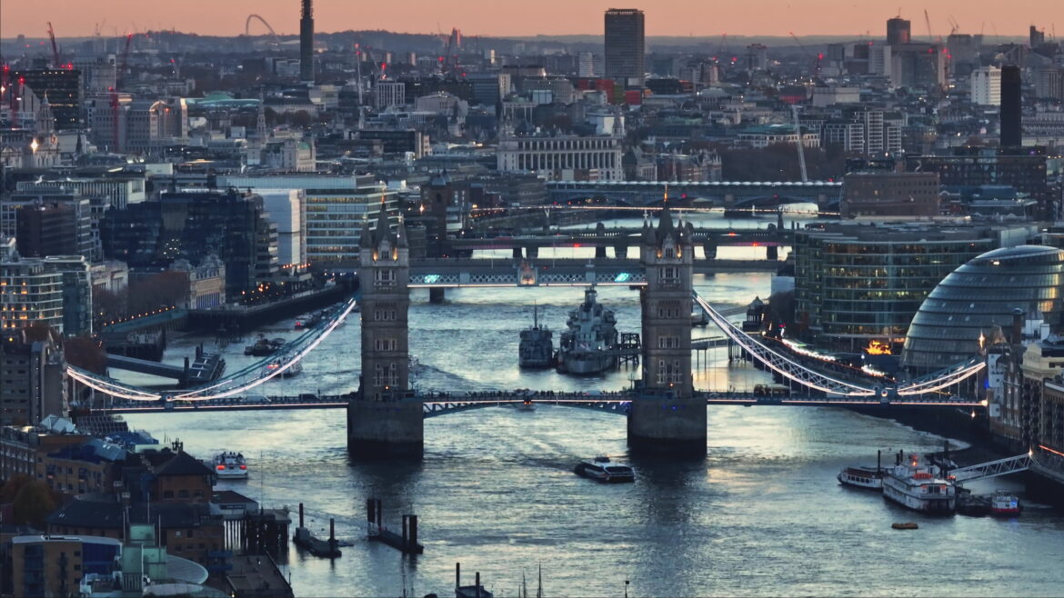 Tower Bridge a Londra al tramonto con il Tamigi e lo skyline della città illuminato