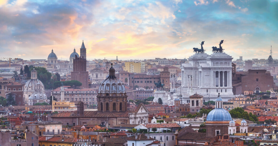 Panorama di Roma al tramonto con i tetti del centro storico e il Vittoriano, immagine in evidenza dell’articolo sugli hotel di lusso a Roma senza glutine.
