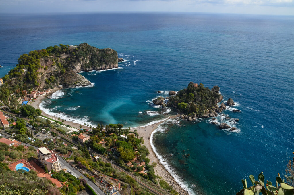 Veduta panoramica di Isola Bella a Taormina con il mare cristallino e la costa della Sicilia orientale.