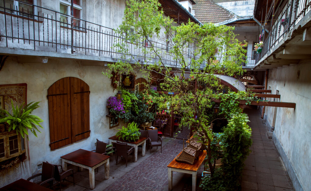 Cortile storico con piante e tavolini nel quartiere Kazimierz di Cracovia