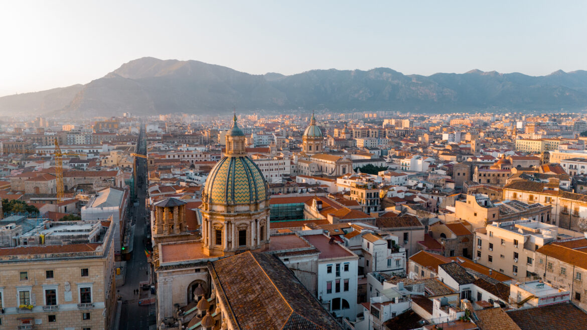 Panorama di Palermo al tramonto con il centro storico e le montagne sullo sfondo