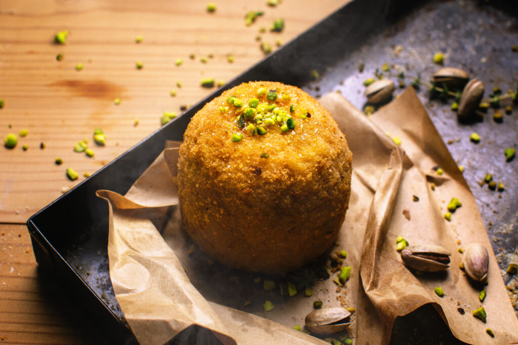 Arancina siciliana con granella di pistacchio, specialità dello street food di Palermo