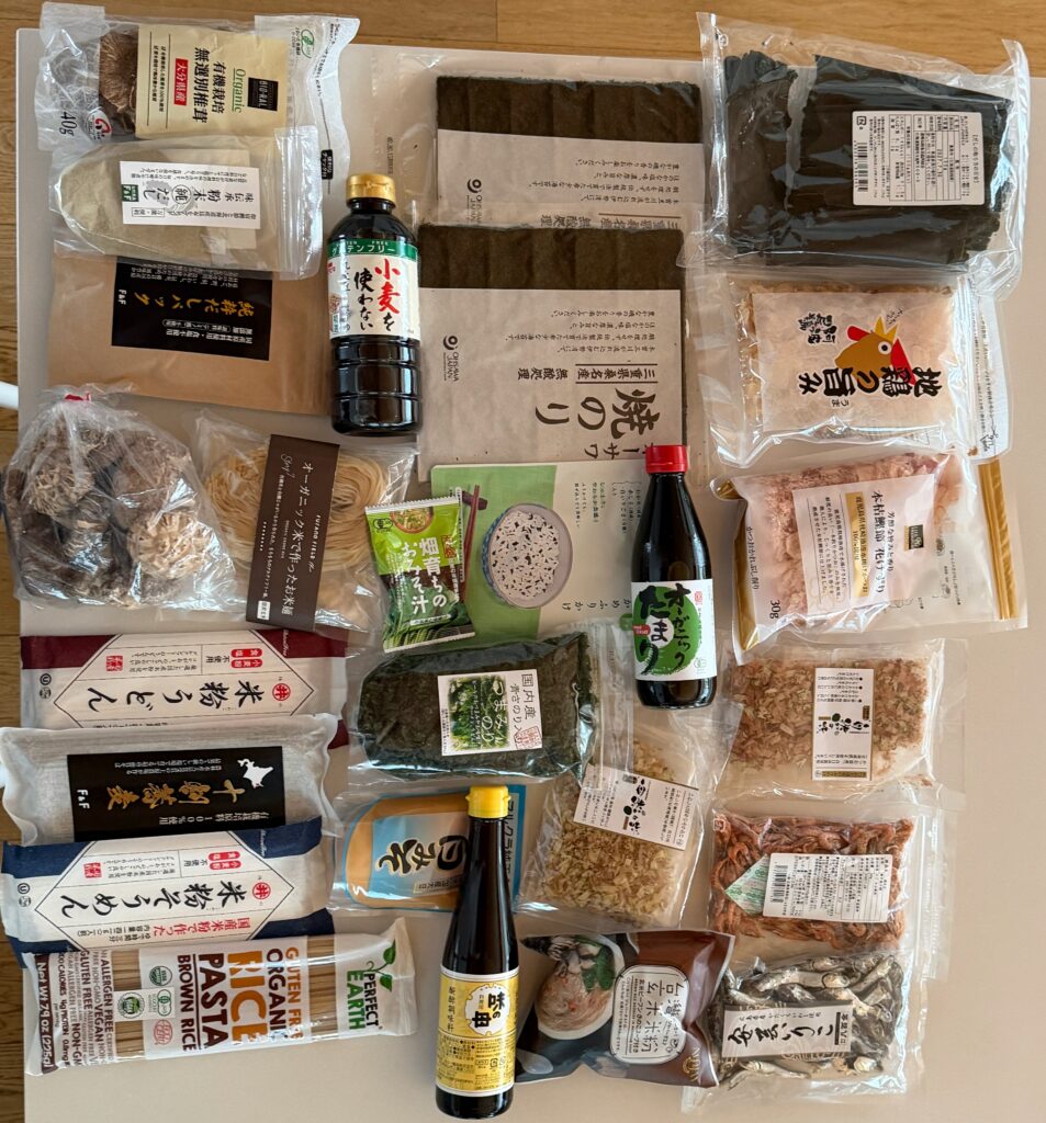 Prodotti alimentari acquistati in Giappone, tra cui salsa di soia, alghe kombu, funghi shiitake, noodles di riso e ingredienti per il dashi.