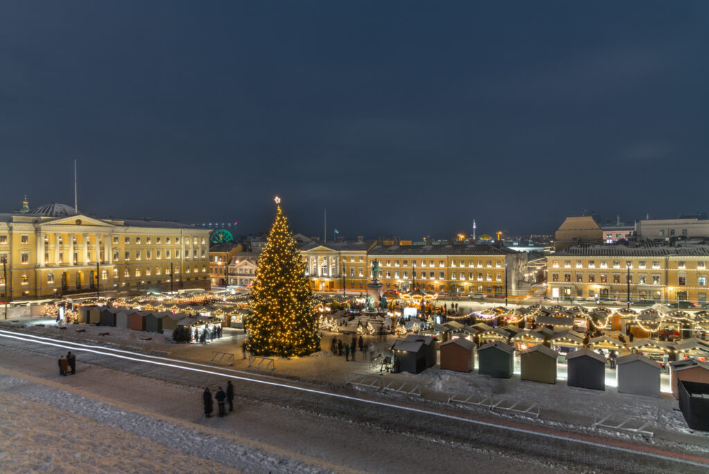 Mercatino di Natale a Helsinki con grande albero illuminato e bancarelle nella Piazza del Senato innevata