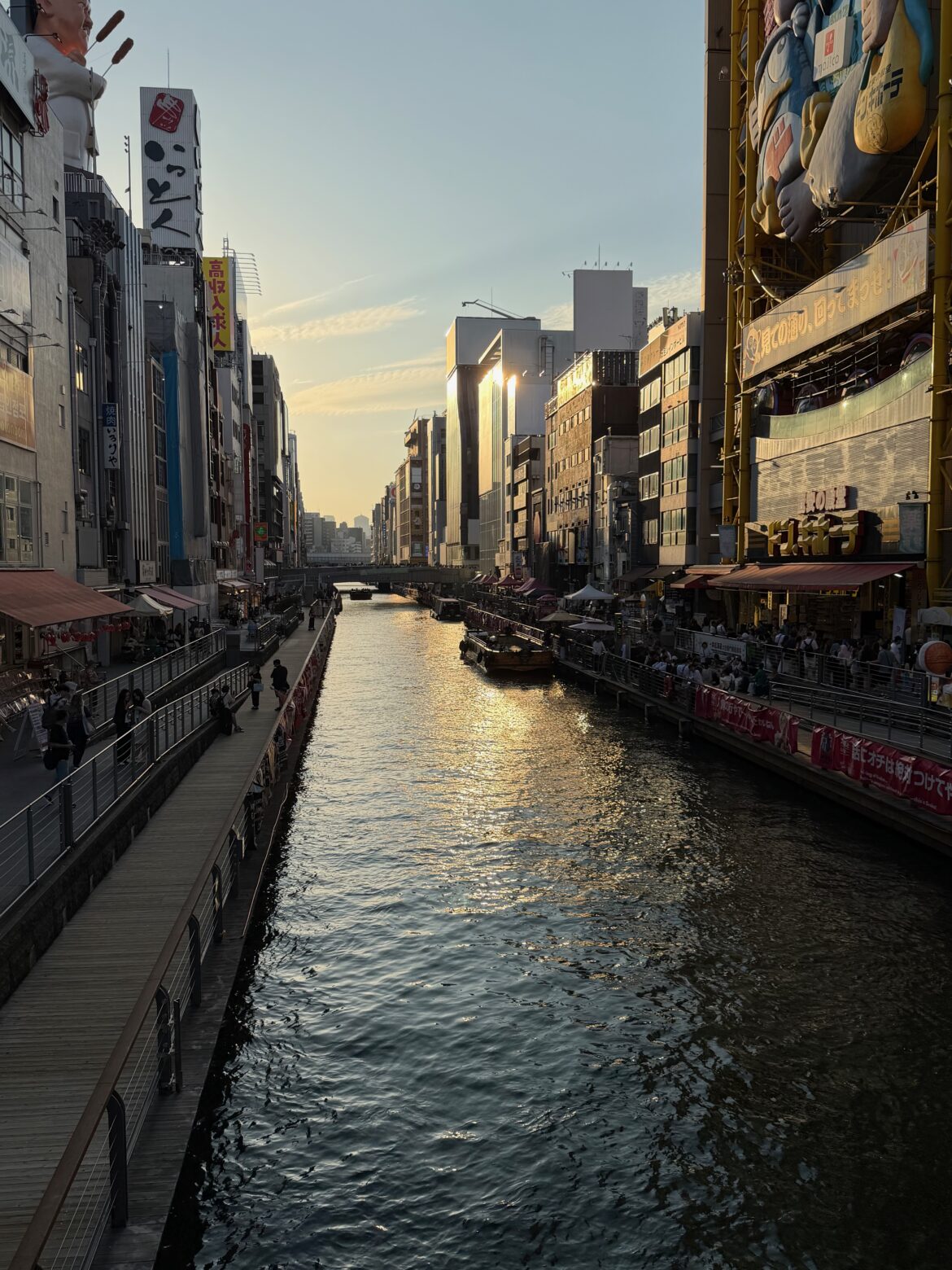Canale di Dotonbori a Osaka al tramonto, con insegne luminose e ristoranti lungo le rive