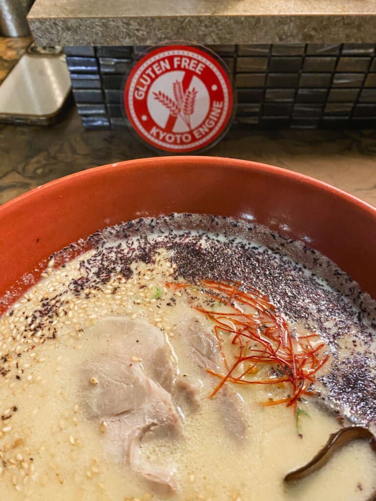 Ciotola di ramen con brodo cremoso, carne, sesamo e condimenti da Engine Ramen a Kyoto.
