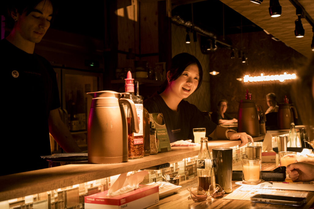 Interno di OSAKA ENGINE RAMEN con bancone, cucina a vista e personale al lavoro