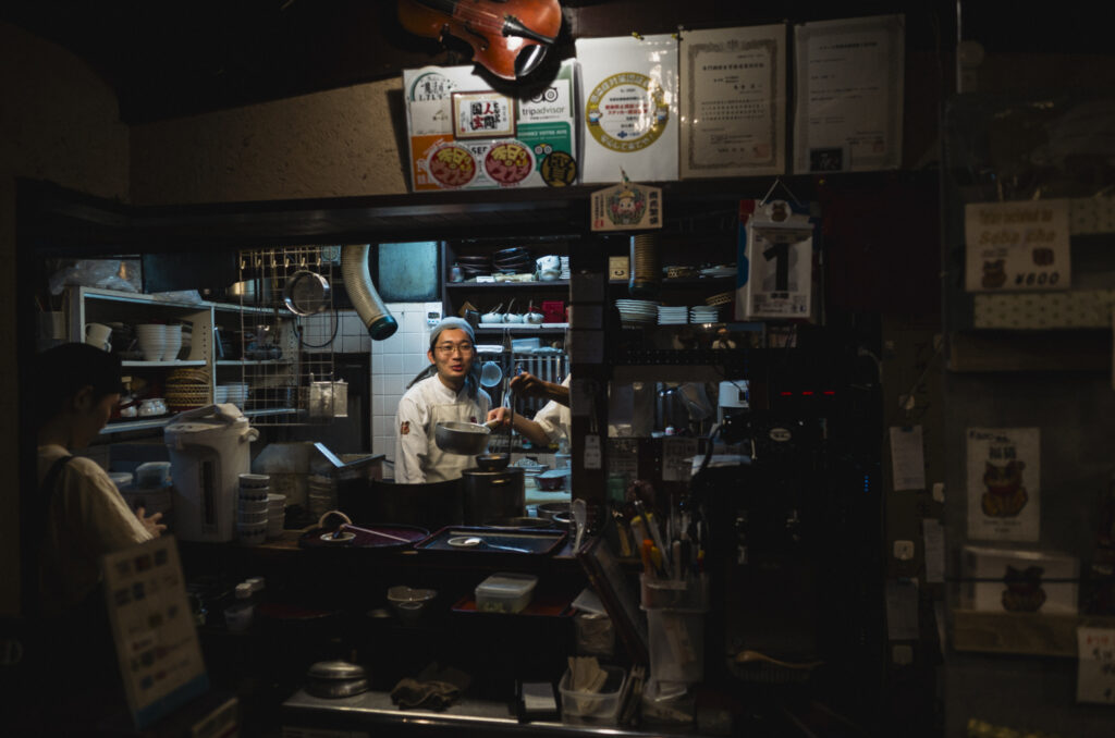 Interno del ristorante Genji Soba a Osaka, con il cuoco al lavoro nella cucina a vista